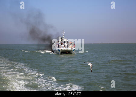 Ein Katamaran Schiff nimmt Touristen aus Teknaf auf St Martin's Island, Aufstoßen, schwarzer Rauch auf dem Weg. Cox's Bazar, Bangladesch. Stockfoto