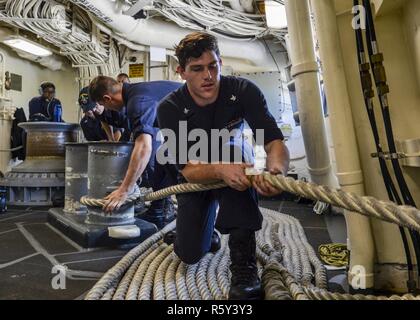 APRA HARBOR, GUAM (20. April 2017) Segler hebe Verankerungsleine während Meer und anker detail an Bord des amphibious Transport dock Schiff USS Essex (LPD-25) als das Schiff in Guam für einen geplanten Hafen besuchen kommt. Somerset, mit der begonnen 11 Marine Expeditionary Unit, arbeitet in der Indo-Asia-pazifischen Region amphibische Fähigkeit mit regionalen Partnern zu verbessern und als gebrauchsfertige Response Force für jede Art der Kontingenz zu dienen. Stockfoto