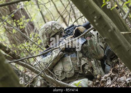 Sgt. Russell Blevins, ein Bewohner von Broken Arrow, Oklahoma, und ein Arzt mit der 45th Infantry Brigade Combat Team in der Ukraine bereitgestellt und bietet Sicherheit für die Kameraden bei einem situationstraining Übung während der 7. Armee Traning Befehl Noncommissioned Officer Academy Basic-Kurs an der Yavoriv Combat Training Center auf dem internationalen Friedens und der Sicherheit, in der Nähe der Yavoriv, Ukraine statt, am 20. April. Stockfoto