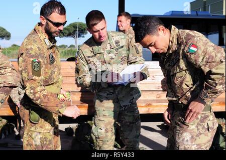 Sgt. Christopher Beseda, eine US-Armee Fallschirmjäger von Alpha Company, 1.BATAILLON, 503Rd Infanterie Regiment, 173Rd Airborne Brigade inspiziert eine italienische Armee Folgore Brigade Fallschirmjäger vor dem Sprung in San Giusto militärischer Flughafen während einer Jumpmaster Kurs, Pisa, Italien, 21. April 2017. ( Stockfoto