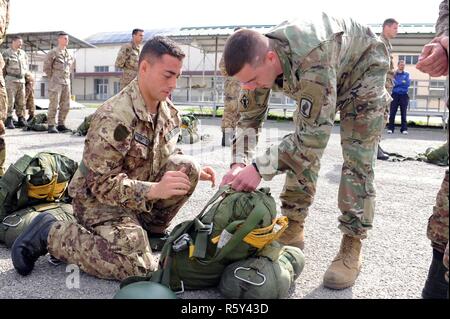 Sgt. Christopher Beseda, eine US-Armee Fallschirmjäger von Alpha Company, 1.BATAILLON, 503Rd Infanterie Regiment, 173Rd Airborne Brigade inspiziert die Ausrüstung eines italienischen Armee Folgore Brigade Fallschirmjäger während der italienischen Jumpmaster Kurs an Gamerra Folgore Airborne Brigade Schule, Pisa, Italien, 13. April 2017. ( Stockfoto