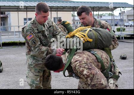 Sgt. Christopher Beseda, eine US-Armee Fallschirmjäger von Alpha Company, 1.BATAILLON, 503Rd Infanterie Regiment, 173Rd Airborne Brigade inspiziert die Ausrüstung eines italienischen Armee Folgore Brigade Fallschirmjäger während der italienischen Jumpmaster Kurs an Gamerra Folgore Airborne Brigade Schule, Pisa, Italien, 13. April 2017. ( Stockfoto