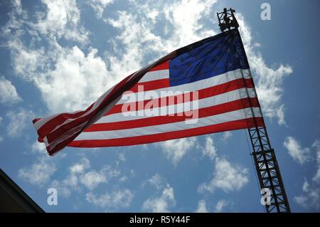 Flagge der Vereinigten Staaten hängt von der Leiter der Puerto Rico Feuerwehr Lkw über die 1 Mission unterstützt den Befehl Plaza PRimeros während der US-Armee finden 109. Geburtstag Feier auf Fort Buchanan, 21. April statt. Stockfoto