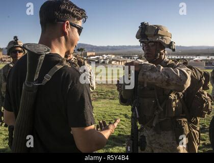 Ein US-Marine gibt eine Rolle Spieler Wasser während Assault Support Taktik 3 (AST-3) im Rahmen der Waffen und Taktiken Instructor Kurs (WTI) 2-17 im Twenty Nine Palms, Kalifornien, 21. April 2017. AST-3 ist eine Übung, die Durchführung von nichtkämpfenden Evakuierung Betrieb (NEO) in einem städtischen Umfeld und bietet gleichzeitig humanitären Auslandshilfe (FHA) für die simulierten Gastgeber im Mittelpunkt. WTI ist eine siebenwöchige Fortbildungsveranstaltung hosted by Marines Aviation Waffen und Taktiken Squadron One (MAWTS-1) Kader, die betriebliche Integration der sechs Funktionen des Marinekorps-Luftfahrt in Unterstützung betont Stockfoto