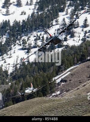 Eine c-130 mit dem 152. Airlift Wing, Nevada Air National Guard, folgt ein U.S. Forest Service Lead Flugzeug in den Bergen östlich von Boise, Idaho als Bestandteil der jährlichen modulare Airborne Fire Fighting System-Ausbildung und Zertifizierung, 21. April 2017. Mehr als 400 Mitarbeiter der vier c-130-Guard und Reserve-Einheiten – aus Kalifornien, Colorado, Nevada und Wyoming, aus denen das Expeditionary Geschwader — sind in Boise für die einwöchige Wildfire Ausbildung und Zertifizierung des U.S. Forest Service gesponsert. Stockfoto