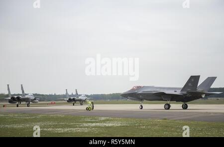 F-15C Adler von der 493Rd Fighter Squadron und eine F-35 ein Lightning II von der 34th Fighter Squadron bei Hill Air Force Base, Taxi zum take-off für ein Training sortie bei Royal Air Force Lakenheath, England, April 20. Die F-35 A ist ein Kämpfer, der fünften Generation bietet die gemeinsame Warfighter beispiellosen globalen Präzision Angriff Fähigkeit gegen aktuellen und neu entstehenden Bedrohungen, während die Ergänzung der Luftwaffe Luftüberlegenheit Flotte. Stockfoto
