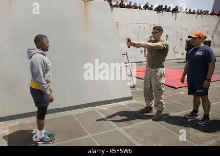 Lance Cpl. Leonardo Castillo, ein militärischer Polizist mit den Strafverfolgungsbehörden Loslösung, 24 Marine Expeditionary Unit (MEU), Sprays ein Seemann mit Oleoresin capsicum als Senior Chief Petty Officer Christopher M.Hausmann, ein Master-at-arms Tauchlehrer während ein Vertrauen Kurs als Teil einer nicht-tödliche Ausbildung an Bord amphibious Transport dock Schiff USS Mesa Verde (LPD 19) April 22, 2017 überwacht. Die 24. MEU ist mit dem Bataan Amphibious Ready Gruppe unterwegs in der Unterstützung der Maritime Security Operations und Theater Sicherheit Zusammenarbeit in den USA 6 Flotte Bereich der Operationen. Stockfoto