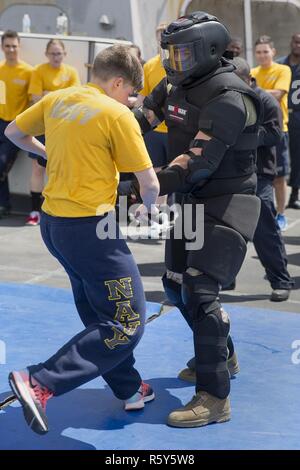 Lance Cpl. Leonardo Castillo, rechts, eine militärische Polizist mit den Strafverfolgungsbehörden Loslösung, 24 Marine Expeditionary Unit (MEU), Balken mit einem Seemann ausgesetzt capsicum Spray während einer vertrauen Kurs oleoresin als Teil einer nicht-tödliche Ausbildung an Bord amphibious Transport dock Schiff USS Mesa Verde (LPD 19) April 22, 2017. Die 24. MEU ist mit dem Bataan Amphibious Ready Gruppe unterwegs in der Unterstützung der Maritime Security Operations und Theater Sicherheit Zusammenarbeit in den USA 6 Flotte Bereich der Operationen. Stockfoto