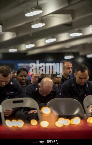Arabischen Golf (24. April 2017) Segler beobachten, ein Moment der Stille, während eine Erinnerung an den Holocaust Zeremonie an Bord der Flugzeugträger USS George H.W. gehalten Bush (CVN 77) (GHWB). GHWB ist in den USA der 5. Flotte Bereich für Maßnahmen zur Erhöhung der Sicherheit des Seeverkehrs auf die Verbündeten und Partnern zu beruhigen bereitgestellt, und der Freiheit der Schiffahrt und des freien Handels in der Region erhalten. Stockfoto