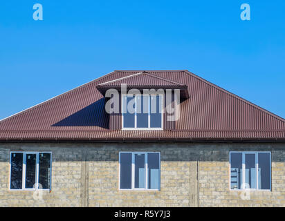 Haus der Schlacke blockieren. Haus mit Kunststoff Fenster und Dach aus Wellblech. Dächer aus Metall Profil wellige Form auf dem Haus mit Kunststofffenster Stockfoto