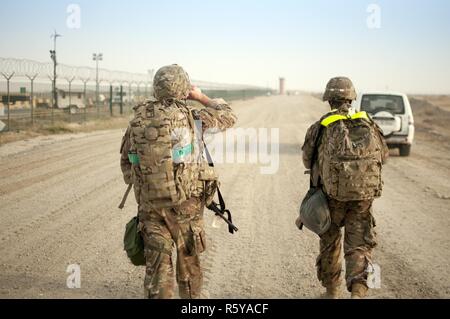 Soldaten in Ihre Richtung schieben, um die Ziellinie des 1 Sustainment Command (Theater) Am besten Krieger Wettbewerb 10 Meile ruck März im Camp Arifjan, Kuwait April 16th, 2017. Stockfoto