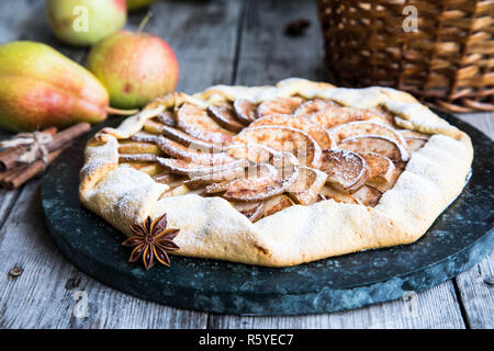 Kuchen mit Äpfeln, Birnen und Zimt auf einem alten hölzernen Hintergrund Stockfoto