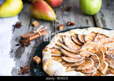 Kuchen mit Äpfeln, Birnen und Zimt auf einem alten hölzernen Hintergrund Stockfoto