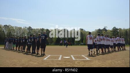 Die verwundeten Krieger Amputee Softball Team stand mit den Newport News Polizei und Feuerwehr während dem Spielen der Nationalhymne am WWAST Spiel in Newport News, Virginia, 15. April 2017. Die WWAST besteht aus Veteranen und Aktiv-Mitglieder, die Gliedmaßen verloren haben, während im Militär seit dem 11. Stockfoto