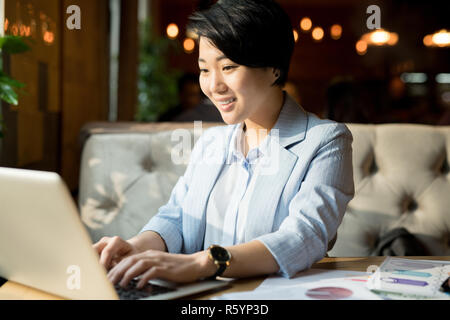 Positive Asiatischen manager Vorbereitung Bericht im Cafe Stockfoto
