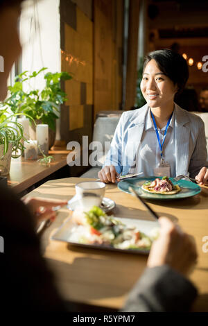 Lächelnd asiatischen Geschäftsfrau ein Mittagessen mit Freund Stockfoto