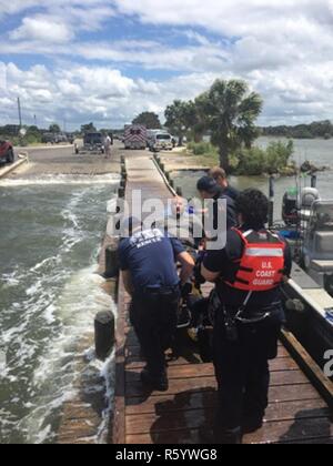 Ein Coast Guard 27-Fuß-Special Purpose Craft-Shallow Wasser Boot Besatzung und Levy County EMS Personal Hilfe ein 32-jähriger Mann am Ende der County Road 40 Boot Rampe, Yankeetown, Florida, Montag, 24. April 2017. Der Mann wurde von einem 33-Fuß-Segelboot und EMS im stabilen Zustand medevacked übertragen. Stockfoto