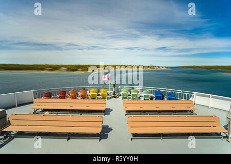 Passagiere auf dem oberen Deck der Fähre Chi-Cheemaun wie er fährt South Baymouth Ferry Terminal an einem sonnigen Frühlingstag, Ontario, Kanada Stockfoto