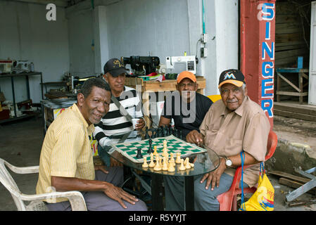 Eine lokale Gruppe Männer Schach spielen außerhalb der Nähmaschine Reparatur Store, in der Nähe von Bazurto Markt. Cartagena de Indias, Kolumbien. Okt 2018 Stockfoto