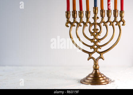 Fragment von Hanukkah und eine Schale mit Olivenöl auf einem weißen Tisch Stockfoto