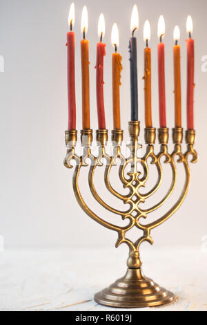 Fragment von Hanukkah und eine Schale mit Olivenöl auf einem weißen Tisch Stockfoto