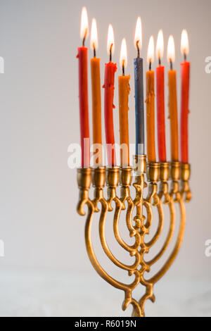 Fragment von Hanukkah und eine Schale mit Olivenöl auf einem weißen Tisch Stockfoto