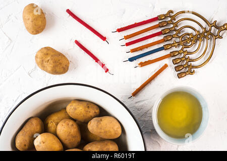 Fragment von Hanukkah und eine Schale mit Olivenöl auf einem weißen Tisch Stockfoto