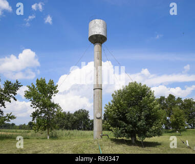 Silber Wasserturm unter grünen Gras und Bäume Stockfoto