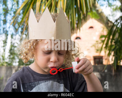 Kleine blonde Junge macht Seifenblasen Stockfoto