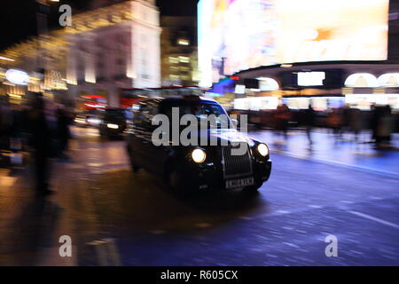 Schwarze Taxi in der Nacht im Piccadilly Circus, London, England, Großbritannien Stockfoto