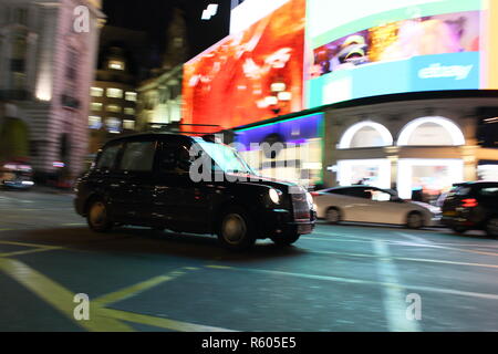 Schwarze Taxi in der Nacht im Piccadilly Circus, London, England, Großbritannien Stockfoto