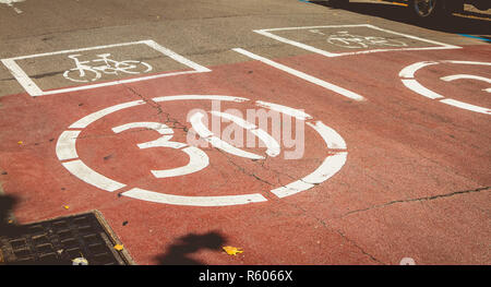 Weiße Farbe auf einem Red Road, die Anwesenheit einer Fahrrad- und Verboten, die Geschwindigkeit von 30 zu überschreiten. Stockfoto