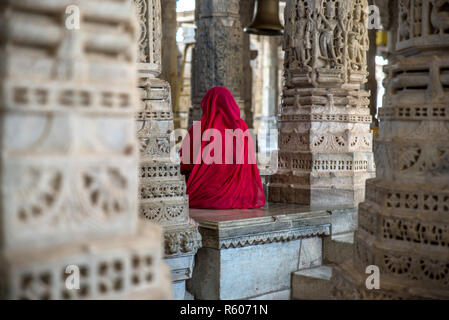 Eine Frau in roten Sari in Ranakpur Jain Temple, Rajasthan, Indien Stockfoto