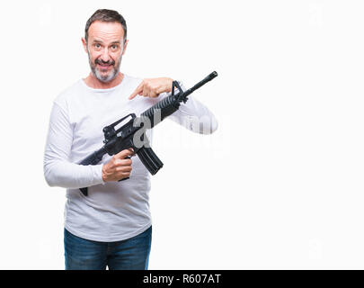 Mittleres Alter senior hoary kriminellen Mann mit Pistole Waffe über isolierte Hintergrund mit Überraschung Gesicht zeigenden Finger zu sich selbst Stockfoto