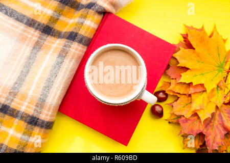 Blätter im Herbst, Buchen, Kastanien, Schal und eine Tasse heiße Schokolade. Herbst, Freizeit und Kaffeepause Konzept. Stockfoto