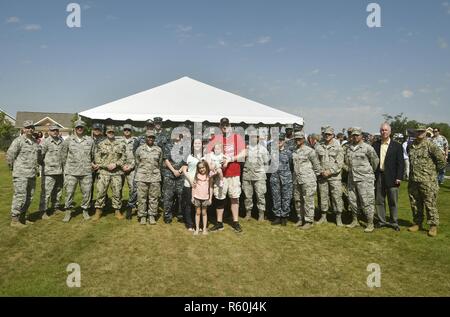 Us Marine Corps Lance Cpl. Jeremy Brooking und seine Familie, Mitte, für ein Gruppenfoto mit Flieger und Matrosen aus Joint Base Charleston beim Spatenstich am Carnes Kreuzung Gemeinschaft darstellen, 22. April 2017, in Summerville, S.C. Brooking während einer Bereitstellung in den Irak im Jahr 2007 und durch die Bemühungen der Betrieb schließlich nach Hause und verschiedenen anderen Organisationen verletzt wurde, wurde eine Hypothek - frei Haus auf die Bedürfnisse der Familie zu passen. Stockfoto