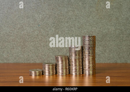 Einsparungen, Erhöhung der Spalten von Goldmünzen, Stapel von Goldmünzen als Grafik auf Schreibtisch, Business Banking Idee. Stockfoto
