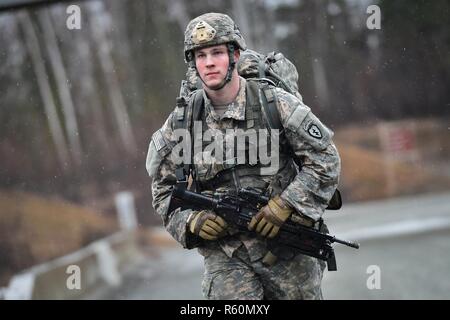 Ein Soldat Comanche Unternehmen, 1.BATAILLON, 501 Fallschirm Infanterie Regiment, 4 Infantry Brigade Combat Team (Airborne), 25 Infanterie Division, U.S. Army Alaska zugewiesen, führt eine 12-Mile taktische Fuß März auf gemeinsame Basis Elmendorf-Richardson, Alaska, 27. April 2017. Fuß marschiert sind, die Bewegung der Truppen und Ausrüstung, vor allem zu Fuß, mit begrenzter Unterstützung von Fahrzeugen. Sie sind durch Kampf Bereitschaft, einfache Steuerung, Anpassungsfähigkeit an Terrain geprägt, langsame Bewegung und höheren Personal Ermüdung. Stockfoto