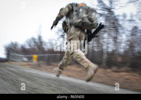 Ein Soldat Comanche Unternehmen, 1.BATAILLON, 501 Fallschirm Infanterie Regiment, 4 Infantry Brigade Combat Team (Airborne), 25 Infanterie Division, U.S. Army Alaska zugeordnet, läuft während eines 12-Meile taktische Fuß März auf gemeinsame Basis Elmendorf-Richardson, Alaska, 27. April 2017. Fuß marschiert sind, die Bewegung der Truppen und Ausrüstung, vor allem zu Fuß, mit begrenzter Unterstützung von Fahrzeugen. Sie sind durch Kampf Bereitschaft, einfache Steuerung, Anpassungsfähigkeit an Terrain geprägt, langsame Bewegung und höheren Personal Ermüdung. Stockfoto