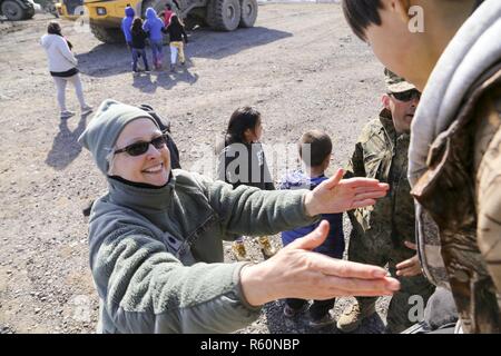 New Mexico Air National Guard Oberstleutnant Cynthia Hale, eine Krankenschwester-Praktiker mit der 150. Medical Group, 150. Special Operations Wing, hilft Studenten nach unten aus einem Fahrzeug bei einem Schulbesuch für das Innovative Readiness Training Start-und Landebahn Erweiterungsprojekt am alten Hafen, Alaska, 20. April 2017. Das US Marinekräfte geführt-Projekt ist Teil eines Zivil- und gemeinsame militärische Programms, militärische Bereitschaft zu verbessern und gleichzeitig die Qualitätsdienstleistungen für unterversorgten Gemeinden in den Vereinigten Staaten. Weitere Teilnehmer sind die Alaska und Arizona Nationalgarde, Air Force Reserve Command, Stockfoto