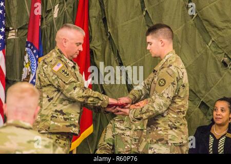 Us-Armee, Command Sgt. Maj. dringen wird, command Sergeant Major des Missouri National Guard, präsentiert der Missouri State Flag zu einem Mitglied der 35th Infantry Division, Übersee und zurück, während einer Bereitstellung Zeremonie, bei Rosecrans Air National Guard Base, St. Joseph, Mo, 28. April 2017. Über 200 Mitglieder der 35 th, in Fort Leavenworth, Kan., für ein Jahr lang, um die Bereitstellung zu Jordanien und Kuwait vorbereitet gehabt. Familie, Freunde und Förderer nahmen an der Zeremonie ihre Lieben aus zu sehen. (Air National Guard Stockfoto