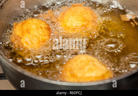 Schritte zur Vorbereitung der traditionellen kolumbianischen Gericht namens gefüllte Kartoffeln: Frittieren gefüllte pototoes Stockfoto