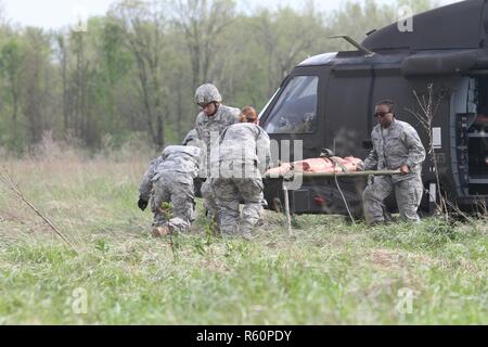 Armee-Reserve Spc. Ryan Flores und Spc. Bailey Jungmann der 469th Medical Company, Wichita, Kansas Verbünde dich mit Air Force Staff Sgt Cherrelle Warren und Flieger 1. Klasse Echo Heldreth 779th Medical Group, Macdill Air Force Base in Tampa, Florida-Ansturm auf einen Schaufensterpuppe Patienten von einem UH-60 Black Hawk-Hubschrauber bei Respondern Unterstützung Camp (RSC) Nighthawk, Indiana während Guardian Antwort 17 am 29. April zu transportieren , 2017.     Fast 5.000 Soldaten und Piloten aus über dem Land beteiligen sich an Guardian Antwort 17, ein Mehrkomponenten Trainingsübung, die militärische Fähigkeit zu validieren Stockfoto