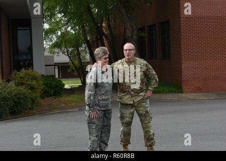 Kaplan Oberstleutnant Debra Kidd, links, engagiert sich in einer freundlichen Begrüßung Umarmung mit Generalmajor Gregory A. Lusk, Recht, während die beiden Zeit verbringen Bereitstellung von Mitgliedern von der North Carolina Air National Guard an der Flightline von der North Carolina Air National Guard Base, Charlotte Douglas International Airport, 28. April 2017 die rechtzeitige Absendung. Bereitstellung am Tag startet die zweite Welle der North Carolina Air National Guards letzte c-130-Bereitstellung, eine Mission zur Unterstützung der Operation Freedom Sentinel. Stockfoto