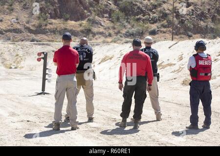 Lieutenant Justin Witcher von Marine Corps Logistik Basis Barstow Marine Corps Polizei überwacht Bereich Sicherheit als CPL. Michael Routson und Officer Jeff Lynn zu schießen während der Duelle Baum-Veranstaltung während der 5. jährlichen Law Enforcement schießen Wettbewerb veranstaltet von Barstow Police Deparment an sein Angebot in Barstow, Kalifornien, April 21. Stockfoto