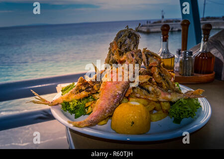 Panierte meerbarbe Filets gebraten auf Kopfsalat Stockfoto