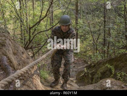 Us Marine Corps Cpl. Carlos S. Camacho, Bestellungen Sekretärin, konsolidierte Administration Center, Sitz und Service-bataillon (H&S BN), Sitz Marine Corps, läuft der Endurance Kurs am Lager Barrett, Quantico, Virginia, 21. April 2017. Marines mit H&S BN lief der Endurance Kurs zu Kameradschaft, der Zusammenhalt und die körperliche Fitness zu erhalten. Stockfoto