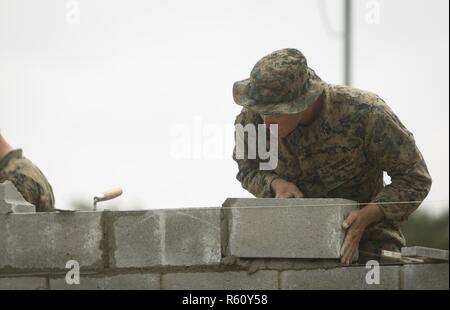 CAMP LEJEUNE, N.C. - Sgt. Tschad R. Stanley, ein schweres Gerät Meister mit der Logistik Combat Element, Special Purpose Marine Air-Ground Task Force - Southern Command, legt ein konkreter Baustein beim Aufbau der Wand eines simulierten Schulhaus während der allgemeinen Übung 2 bei Marine Corps Base Camp Lejeune in North Carolina, 28. April 2017. Die Marines simulierten Bau eines Schulhauses in der Vorbereitung für die Verbesserung der Infrastruktur Projekte in der kommenden Bereitstellung zu Mittelamerika geplant. Stockfoto