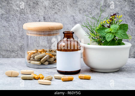 Alternative health care frische Kräuter Rosmarin, Zitrone, Thymian, Fenchel, Pfefferminze, Basilikum Blume und pflanzliche Kapsel mit Mörtel auf Stein. Stockfoto