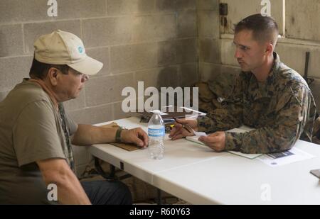 CAMP LEJEUNE, N.C. - Sgt. Austin S. Cody, der Logistikspezialist mit der Logistik Combat Element, Special Purpose Marine Air-Ground Task Force - Southern Command, Register eine Rolle Spieler an einer simulierten Evakuierung Control Center während der allgemeinen Übung 2 bei Marine Corps Base Camp Lejeune in North Carolina, 29. April 2017. Die Marines simuliert eine noncombatant Evakuierung, um für Krisen Situationen, die Sie während Ihrer Bereitstellung zu Mittelamerika gegenüberstellen könnte, vorzubereiten. Stockfoto